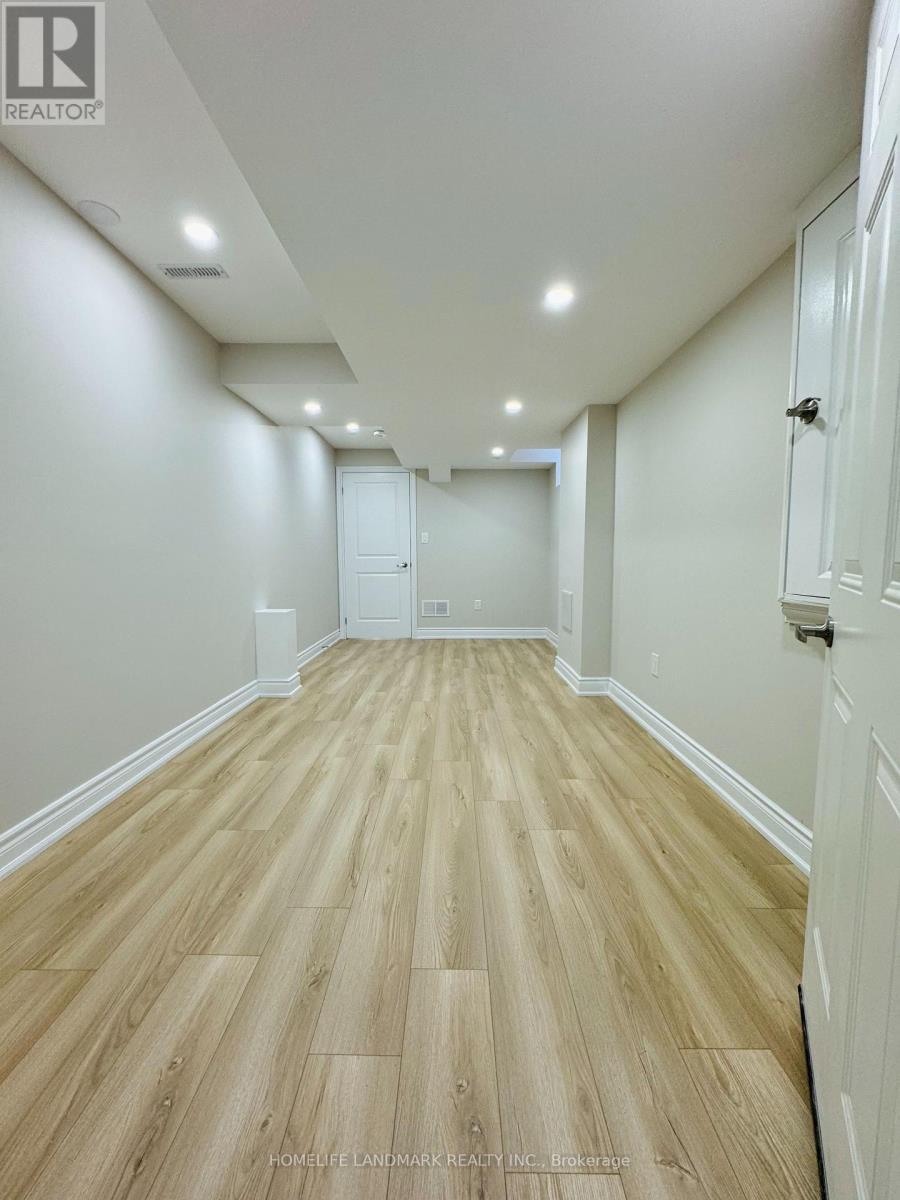 A long hallway with wood floors and white walls.