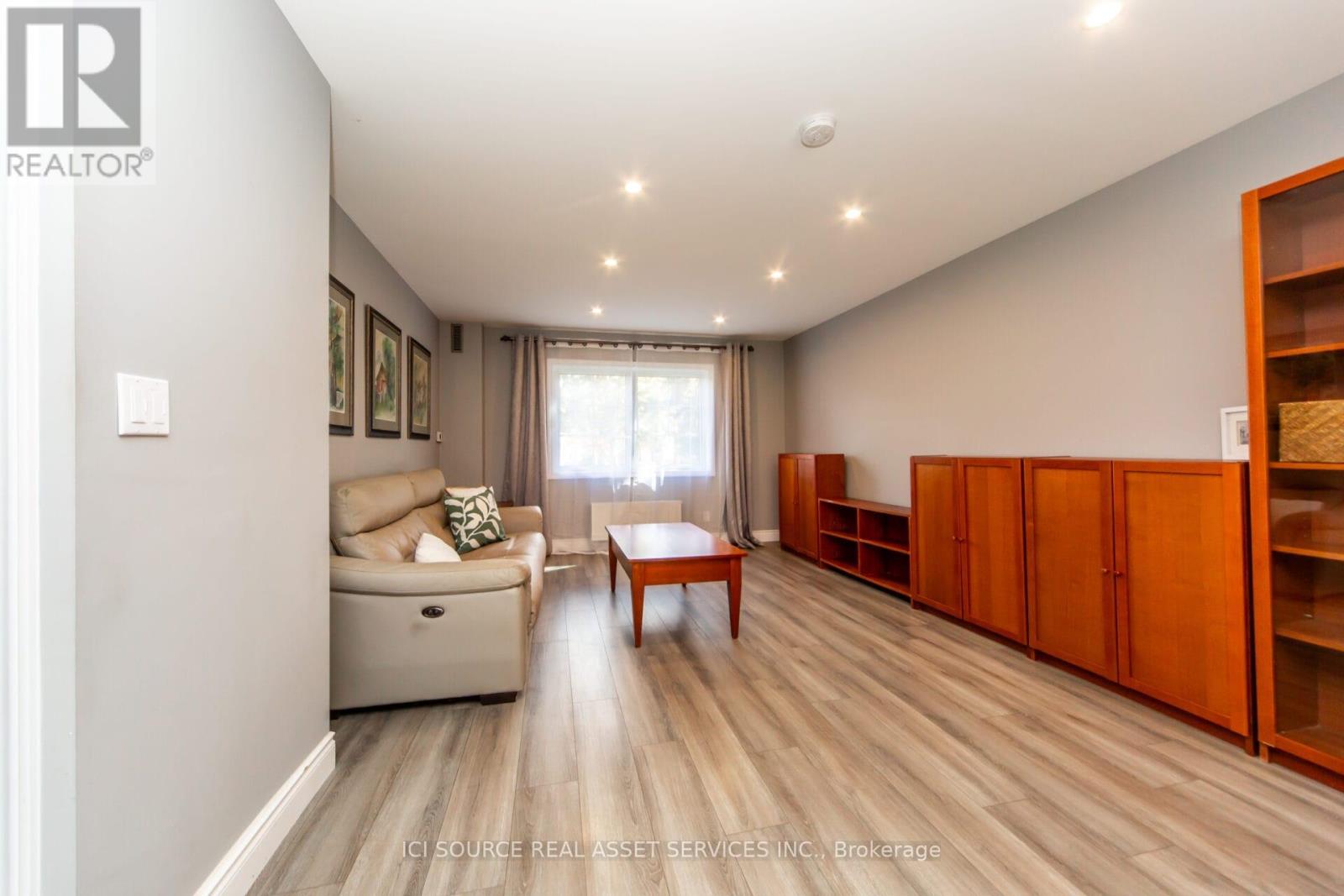 A spacious living room with a couch, coffee table, and built-in shelves.
