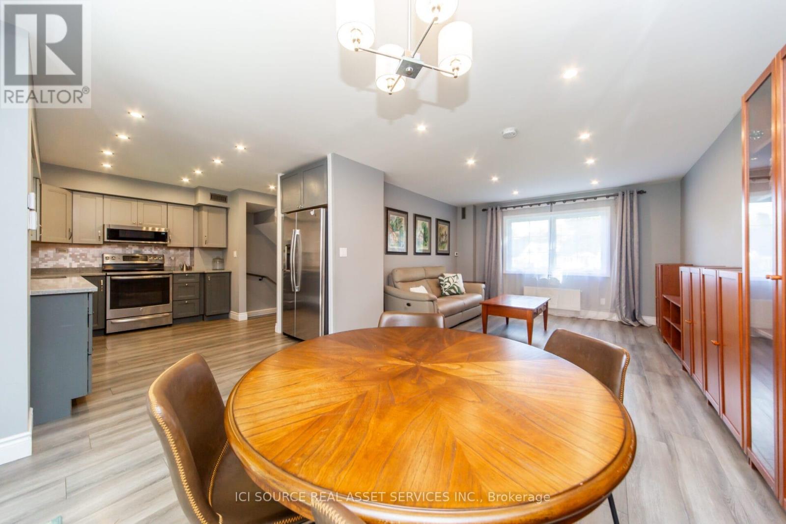 A modern kitchen with a wooden table and chairs.