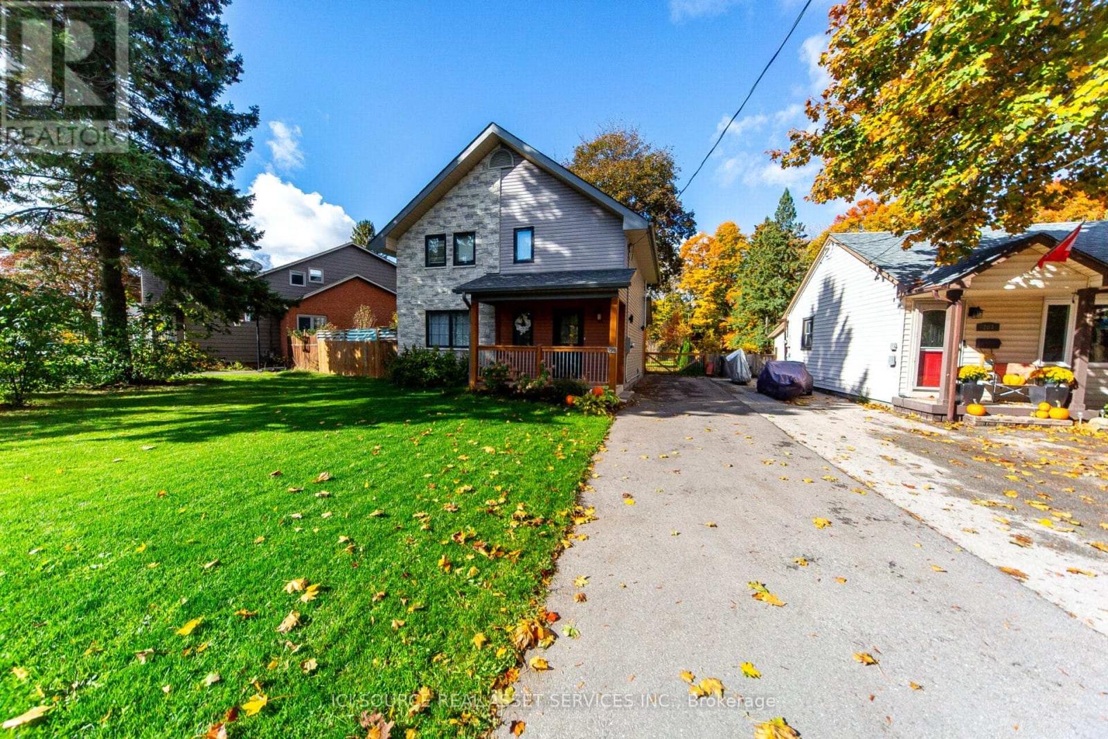 A house with a driveway and trees in the background.