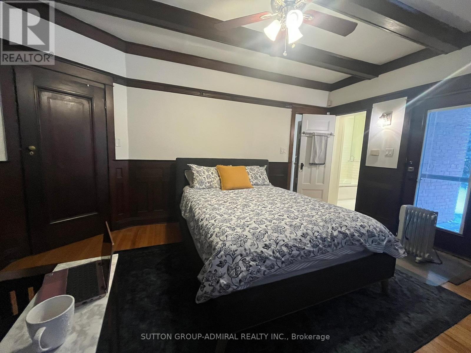 A bedroom with a bed, a table, and a chair.