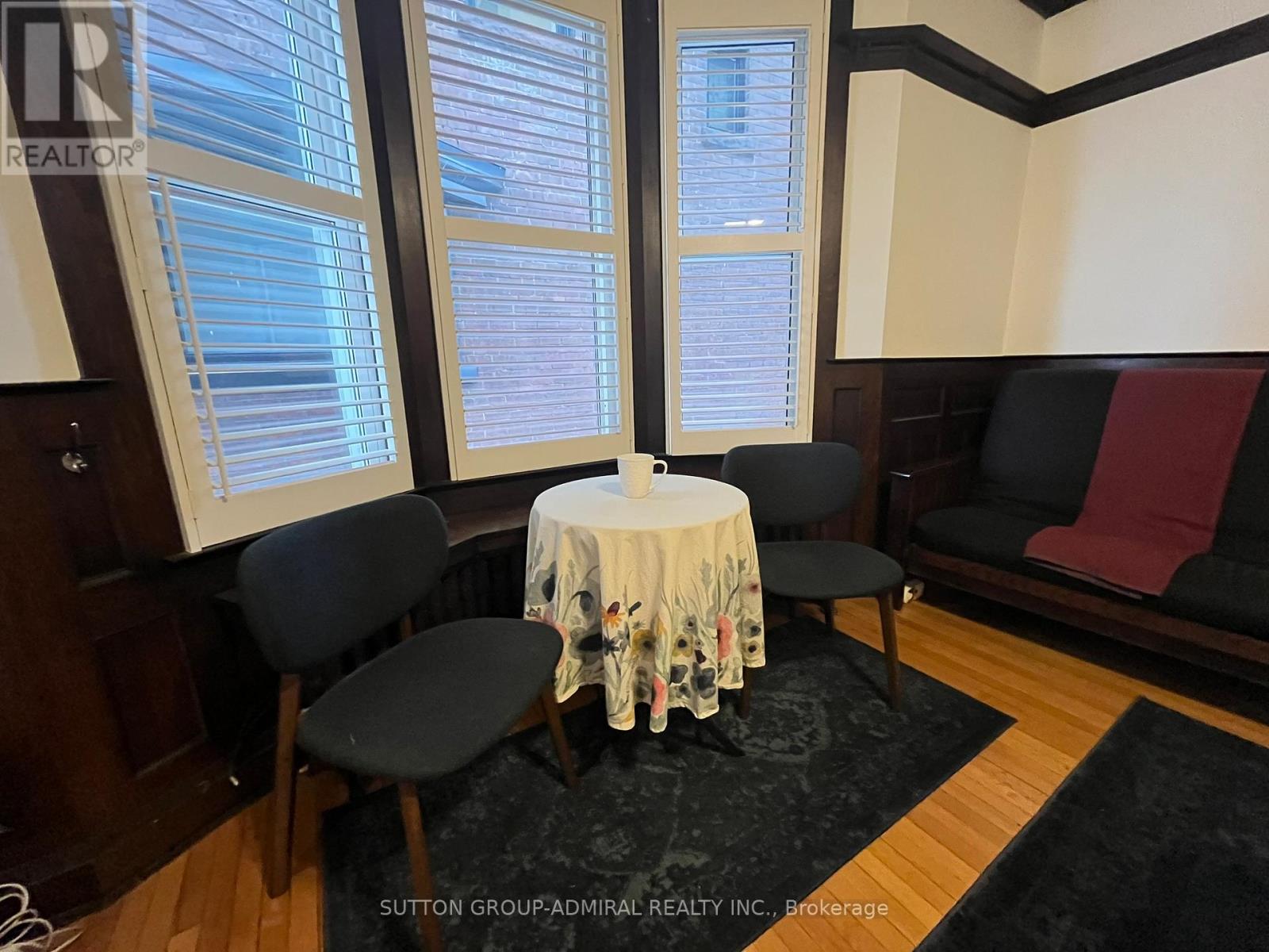 A dining room with a round table and chairs.