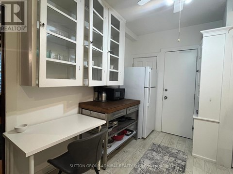 A kitchen with white cabinets and a white table.