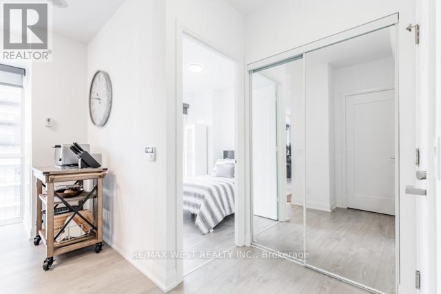 A white bedroom with a bed and a desk.