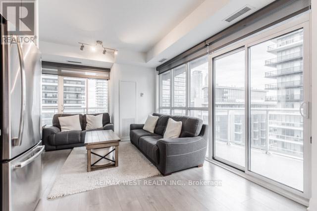 A modern living room with a grey couch and a large window.