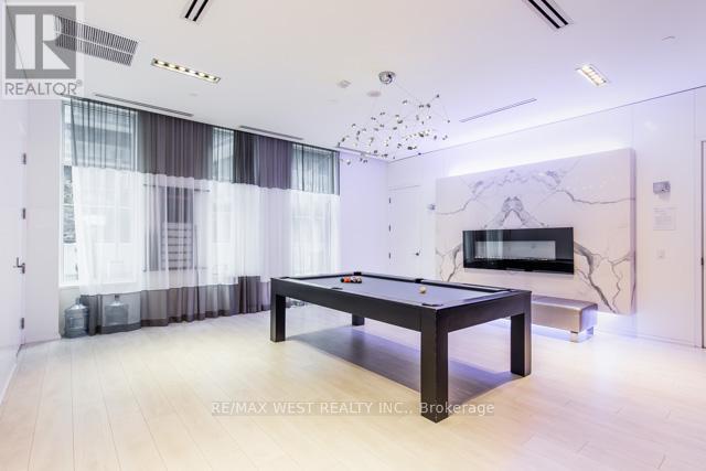 A pool table in a room with a white ceiling and a chandelier.