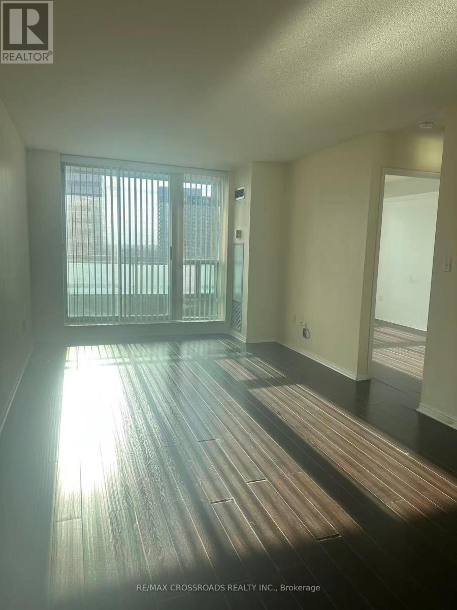 A room with a large window and wooden floors.