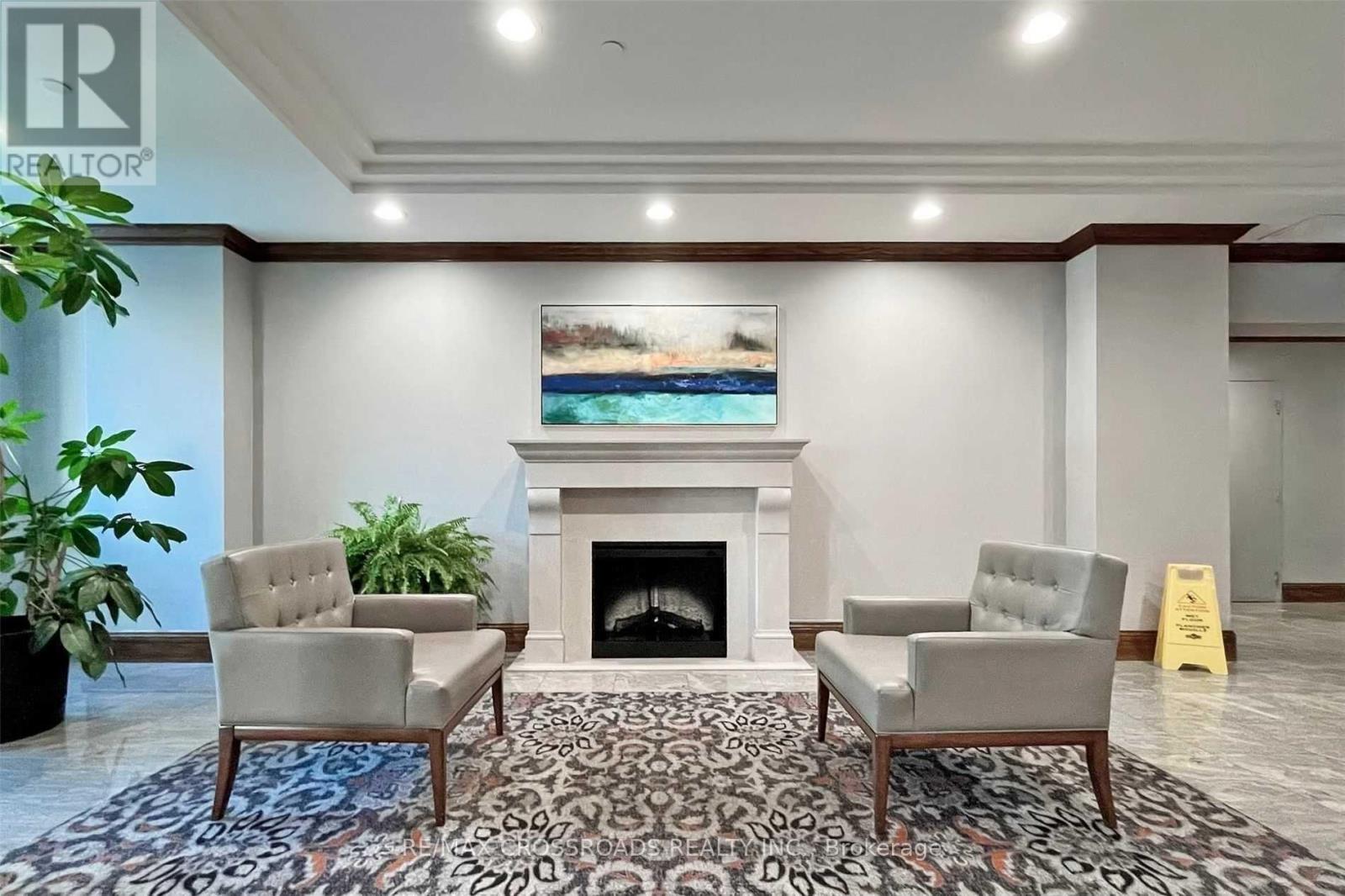 A living room with a fireplace and two chairs.