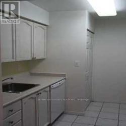 A kitchen with white cabinets and a white fridge.