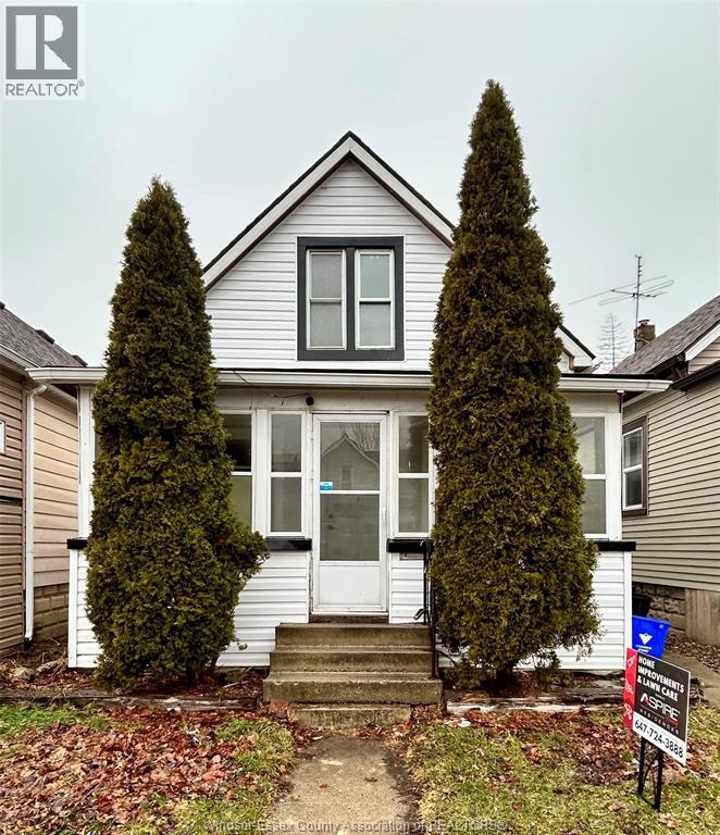 A house with a sign in front of it that says "For Sale".