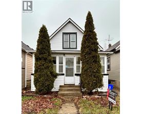 A house with a sign in front of it that says "For Sale".