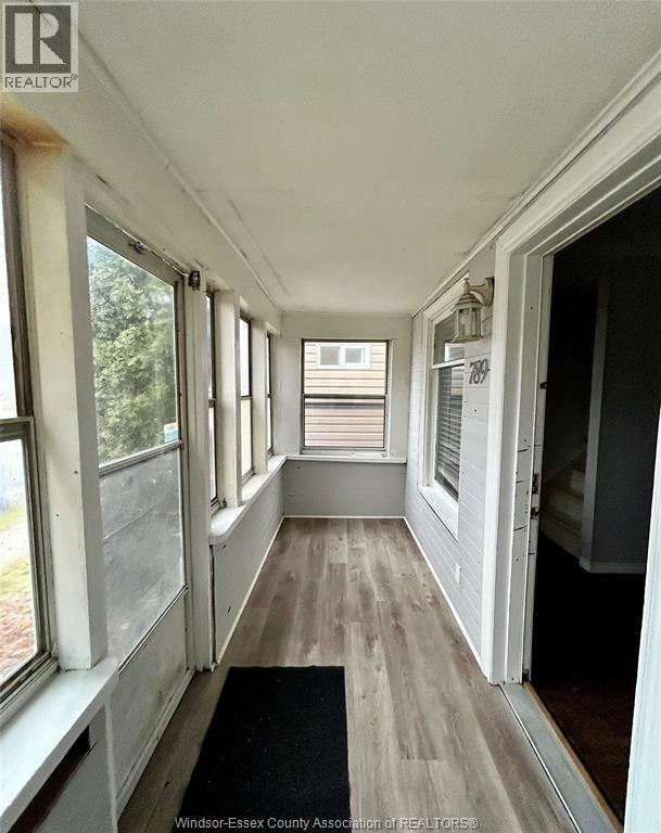 A hallway with a black mat on the floor and windows on both sides.