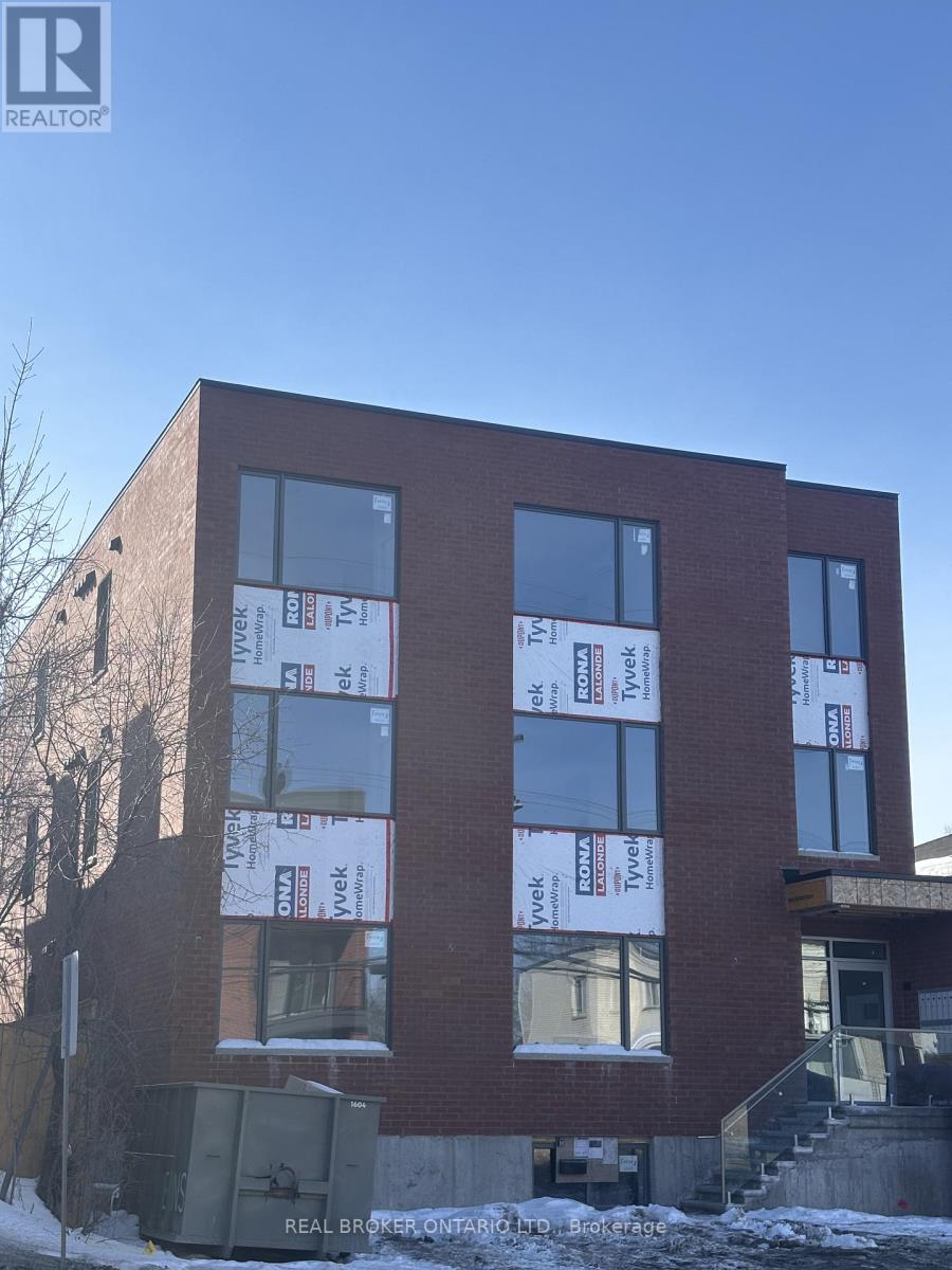 A building under construction with the words "Real Broker" written on the top left corner.