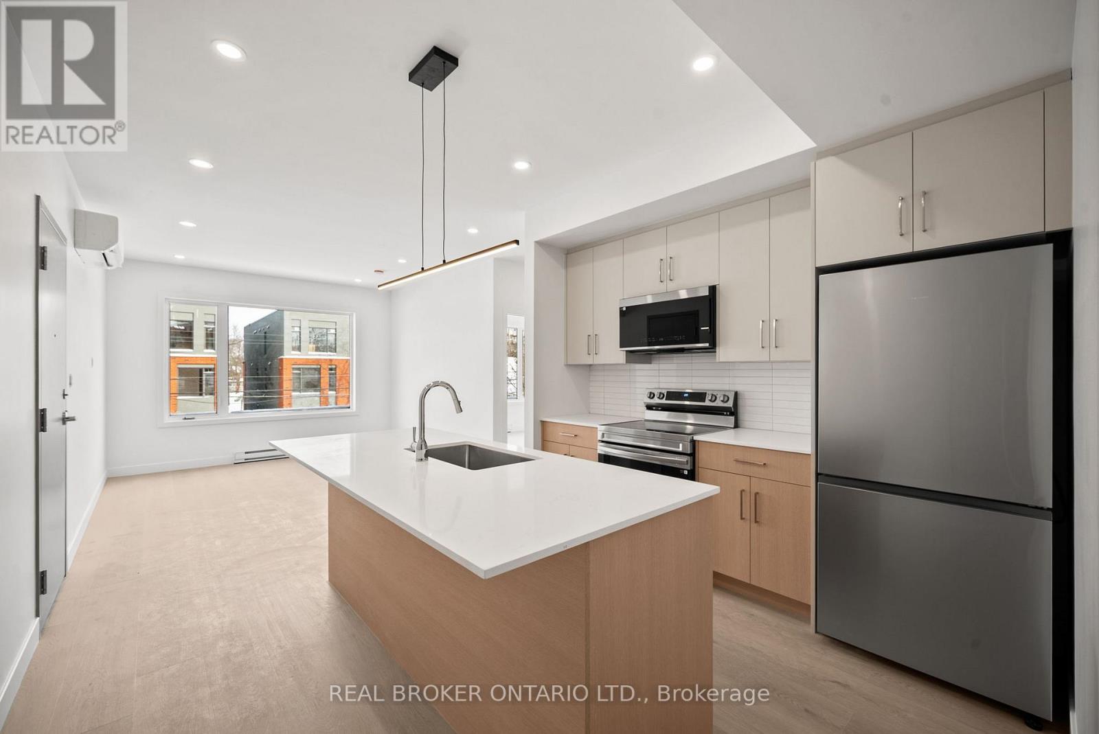 A modern kitchen with a large island and stainless steel appliances.
