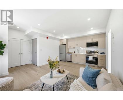 A modern kitchen with a large island and a washing machine tucked away in the corner.