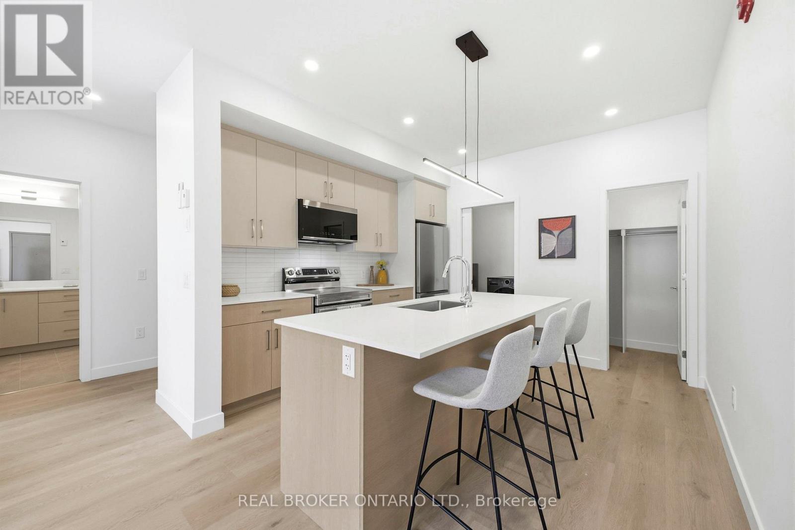 A modern kitchen with a large island and a washing machine tucked away in the corner.