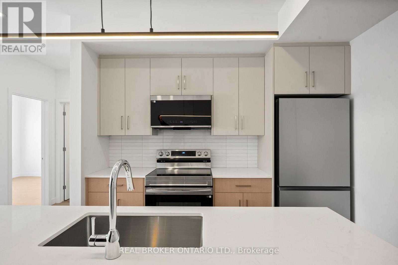 A modern kitchen with a stainless steel sink and appliances.