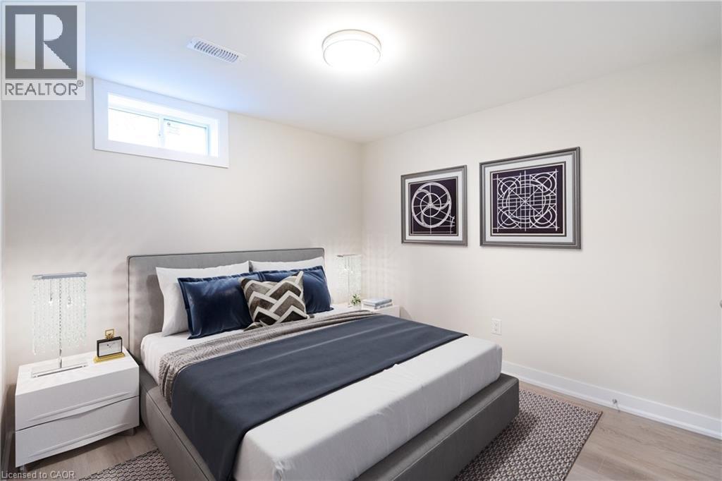 A bedroom with a large bed and two pictures on the wall.