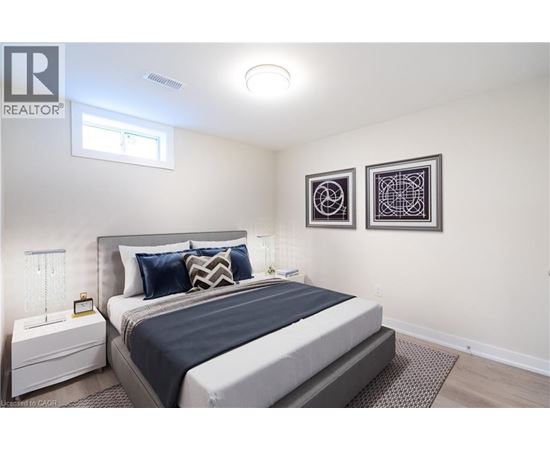 A bedroom with a large bed and two pictures on the wall.