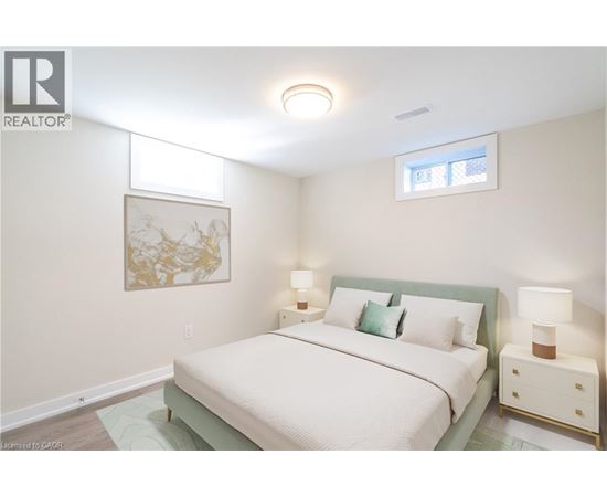A bedroom with a bed, nightstands, and a painting on the wall.