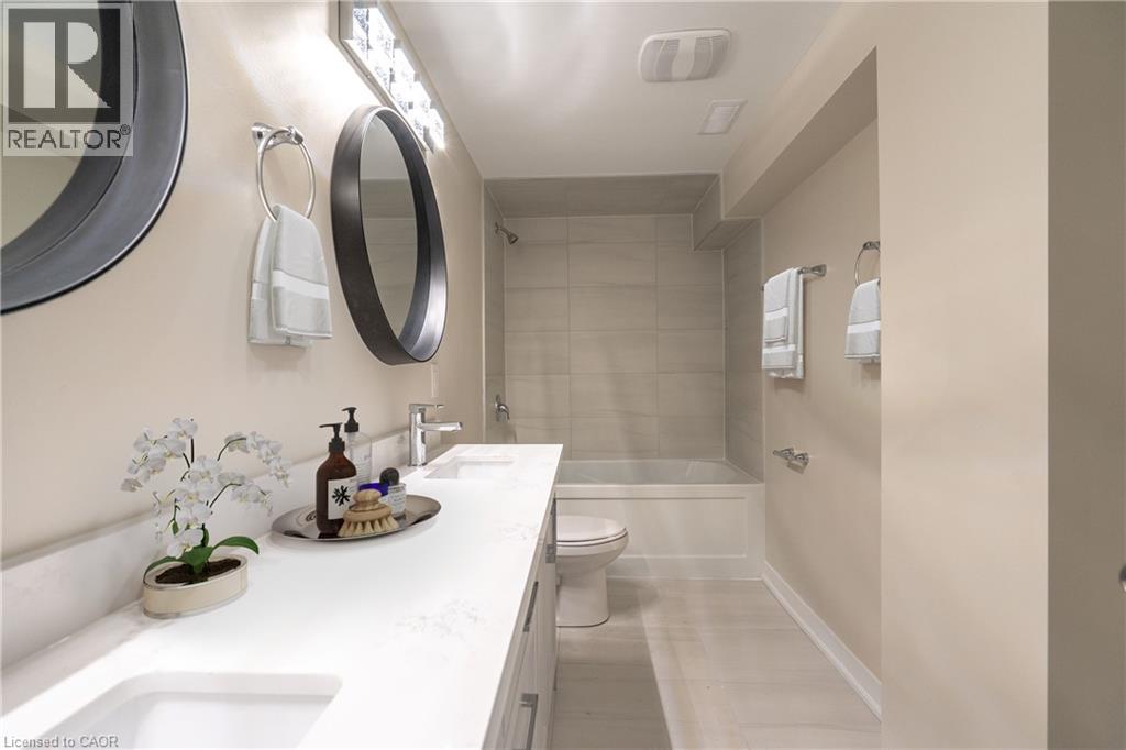 A bathroom with a sink, mirror, toilet, and shower.