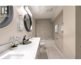 A bathroom with a sink, mirror, toilet, and shower.