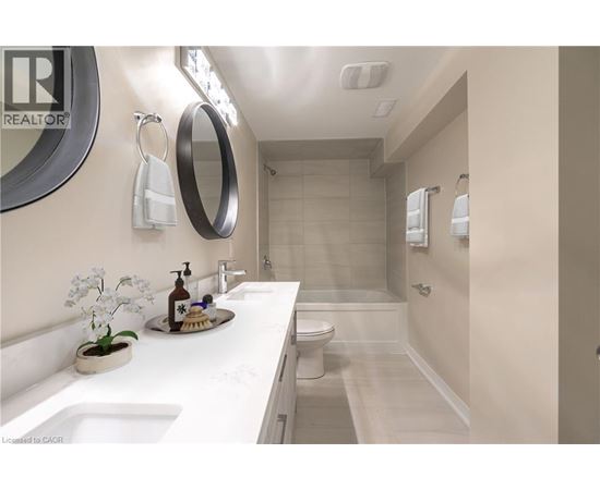 A bathroom with a sink, mirror, toilet, and shower.