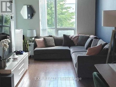 A living room with a grey couch and a wooden table.