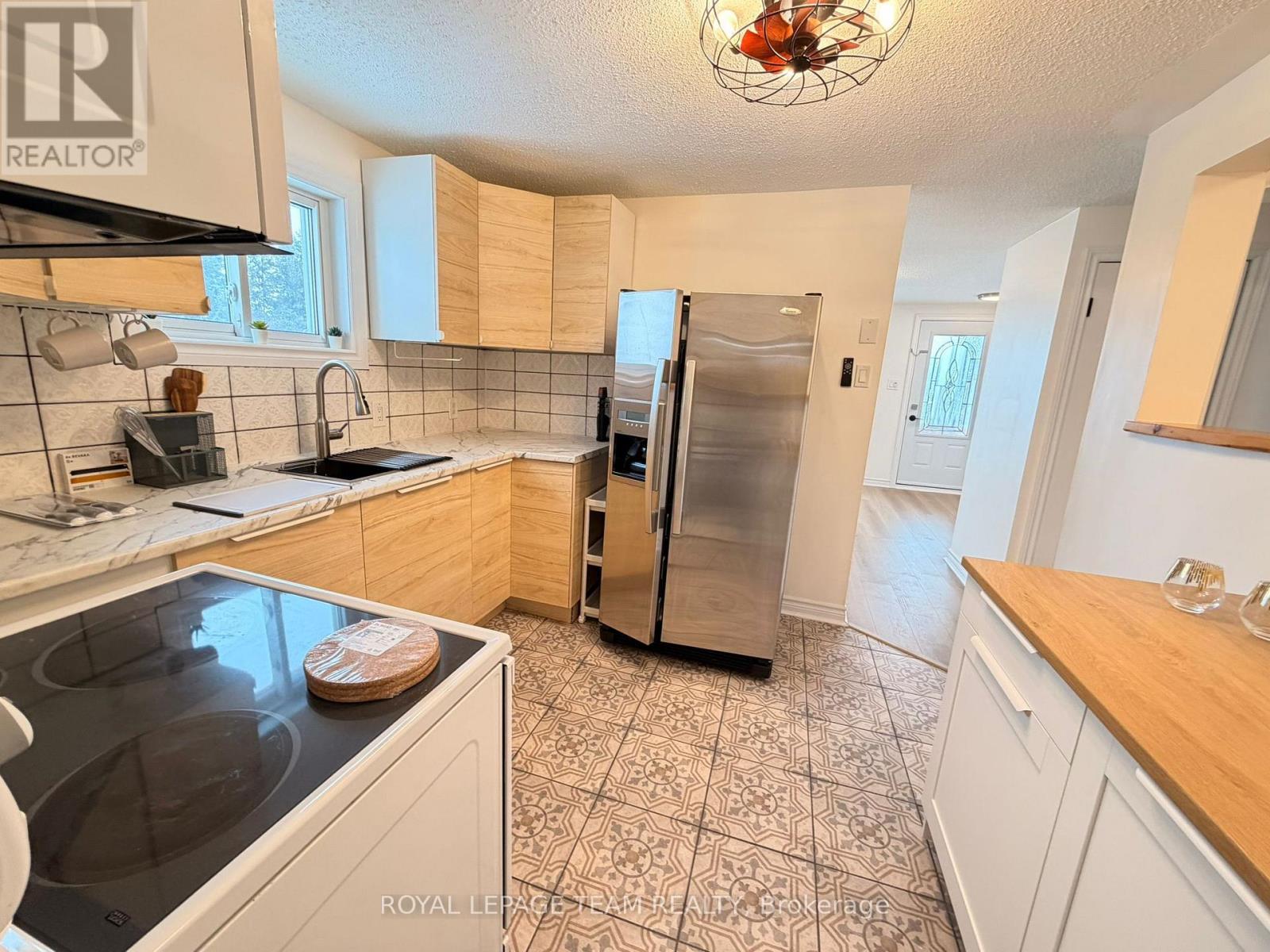A kitchen with a white counter and a black refrigerator.