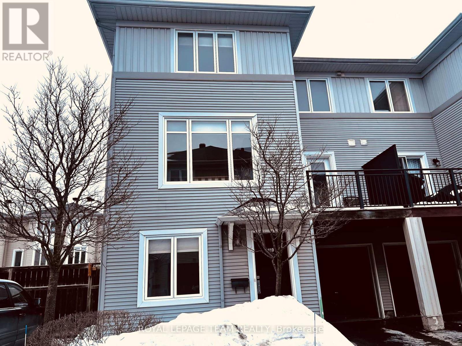 A blue house with a sign that says "REALTOR" in the top left corner.