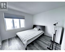 A bedroom with a bed, wooden floors, and a window.