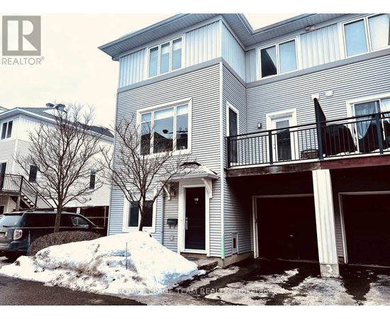 A house with a grey and white exterior and a balcony.