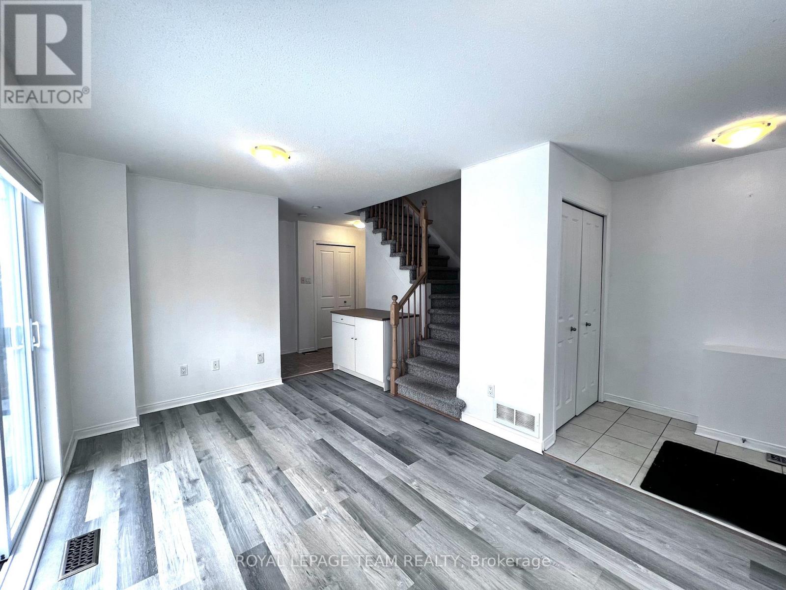 A spacious room with a staircase leading to the upper floor.