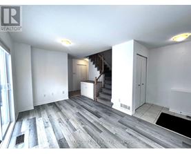 A spacious room with a staircase leading to the upper floor.