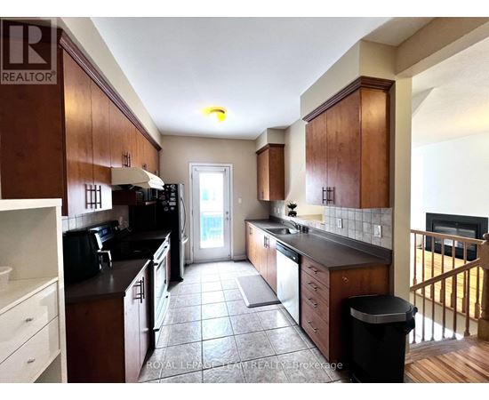 A kitchen with brown cabinets and black appliances.
