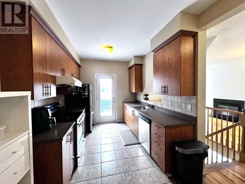 A kitchen with brown cabinets and black appliances.