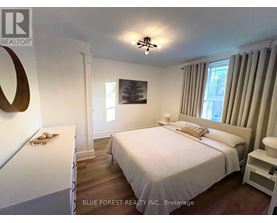 A bedroom with a large bed and a painting on the wall.