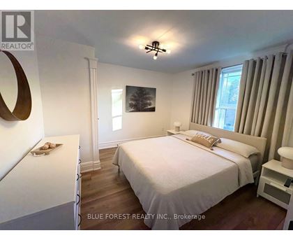 A bedroom with a large bed and a painting on the wall.