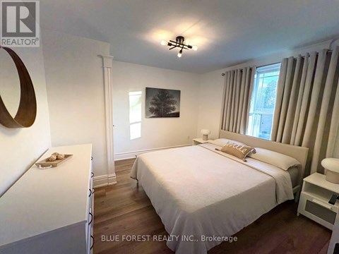 A bedroom with a large bed and a painting on the wall.
