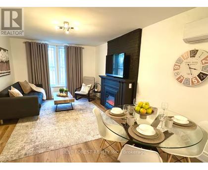 A living room with a couch, chairs, a coffee table, and a fireplace.