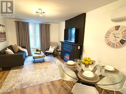 A living room with a couch, chairs, a coffee table, and a fireplace.
