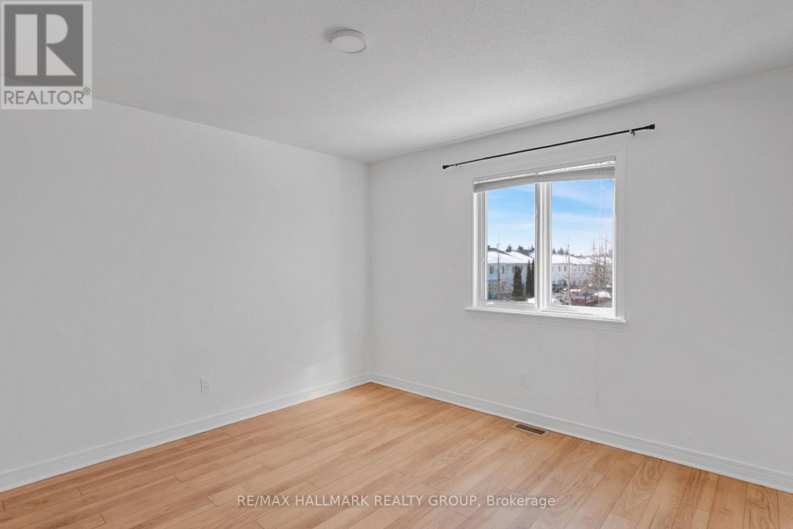 A room with a window showing a view of trees and sky.