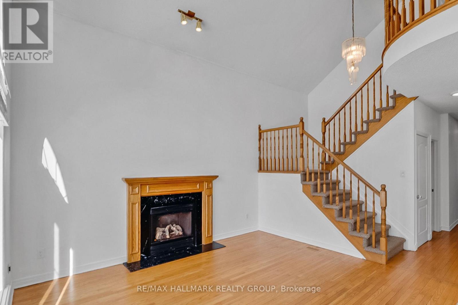 A living room with a fireplace and a staircase.