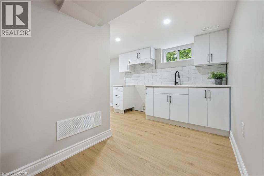 A kitchen with white cabinets and a window above the sink.