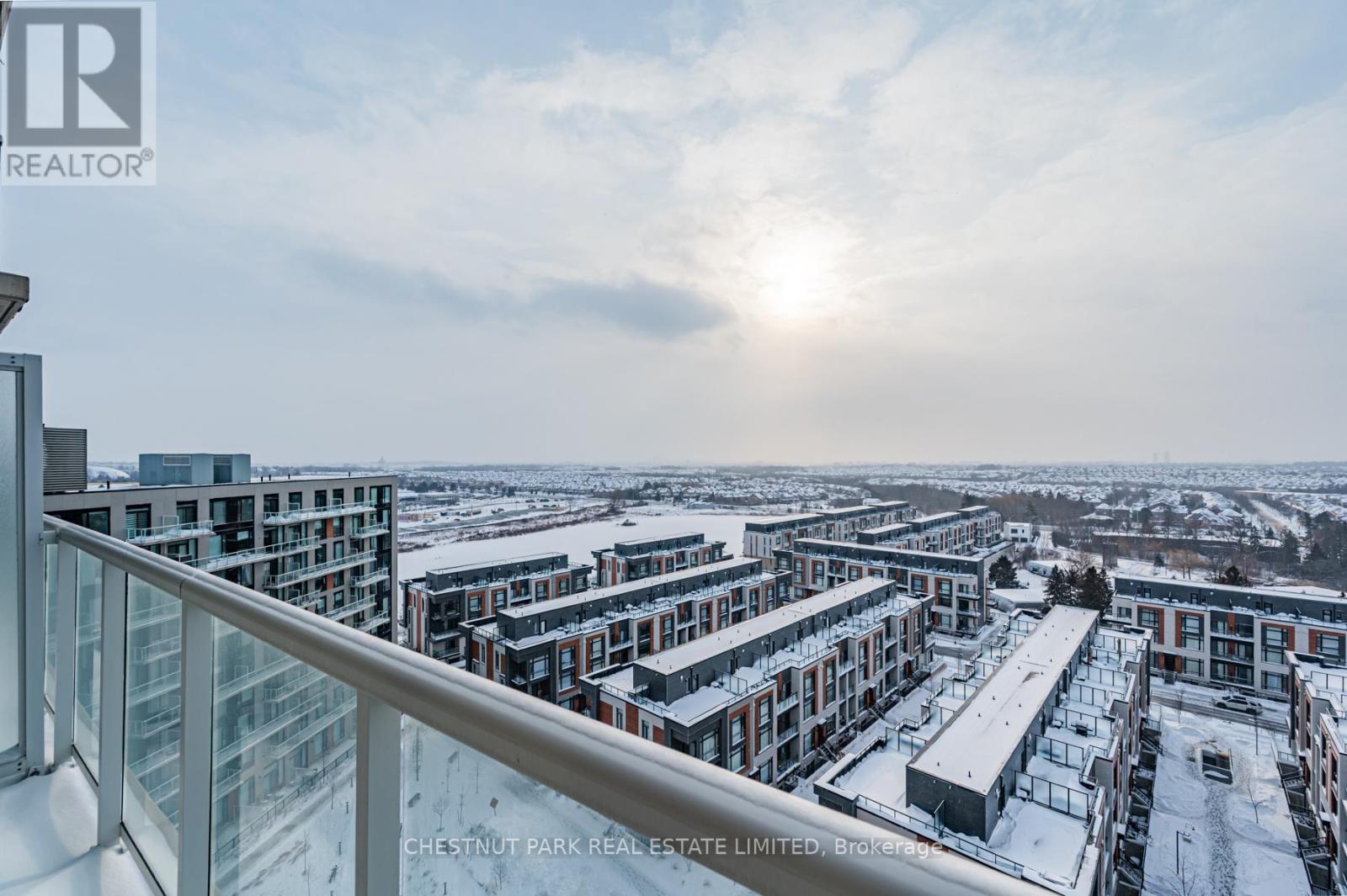 A view from a balcony overlooking a snowy landscape with multiple buildings.