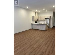 A kitchen with wooden floors and white walls.