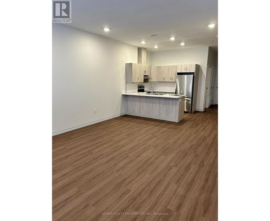 A kitchen with wooden floors and white walls.