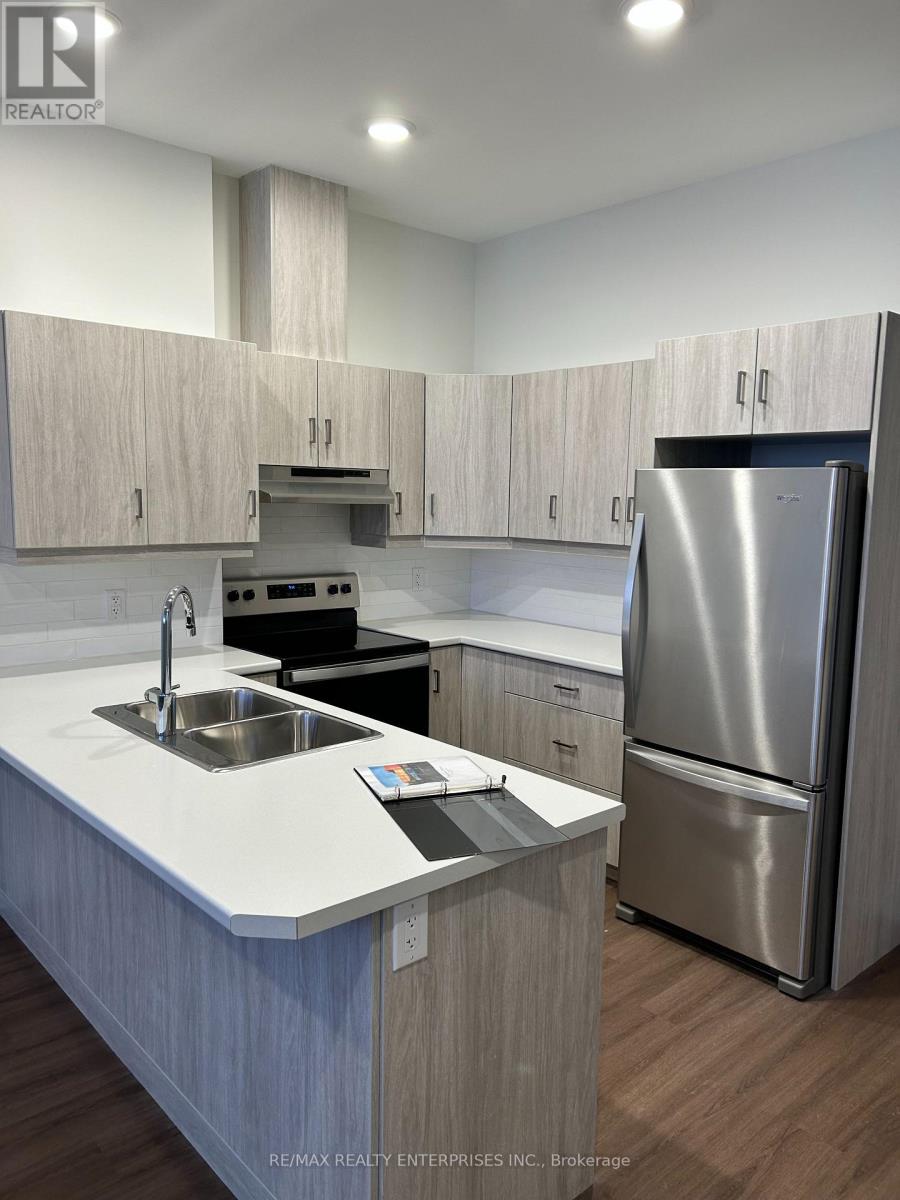 A modern kitchen with a stainless steel refrigerator and wooden cabinets.