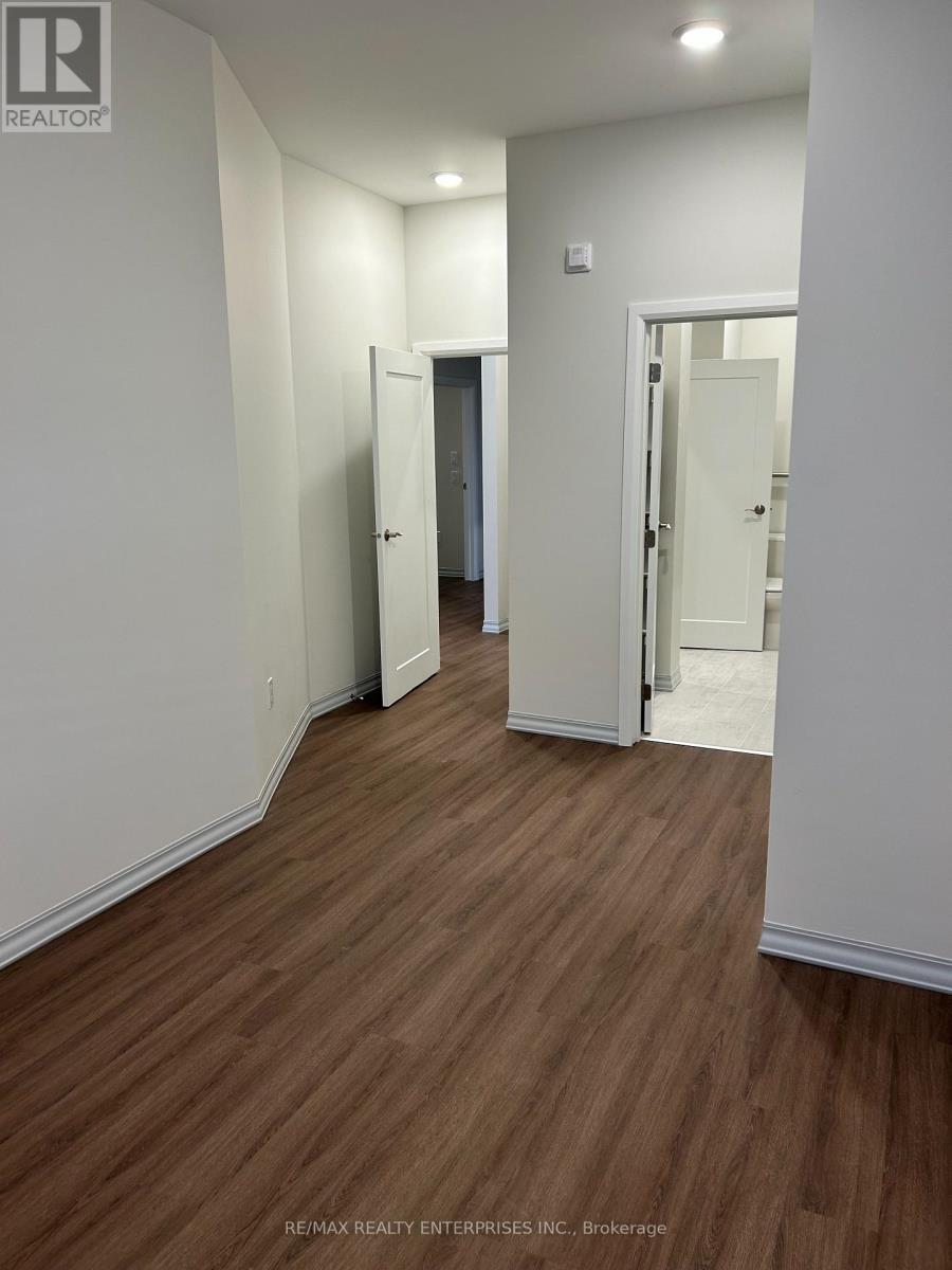 A hallway with wood flooring and white walls.