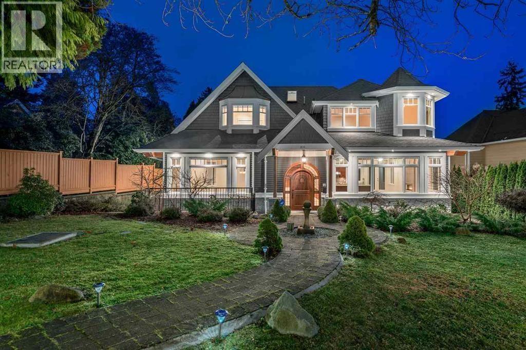 A large house with a well-maintained lawn and a driveway leading to the front door.